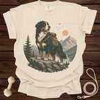 Bernese Mountain Dog wearing a backpack in a mountain landscape on a cream t-shirt.