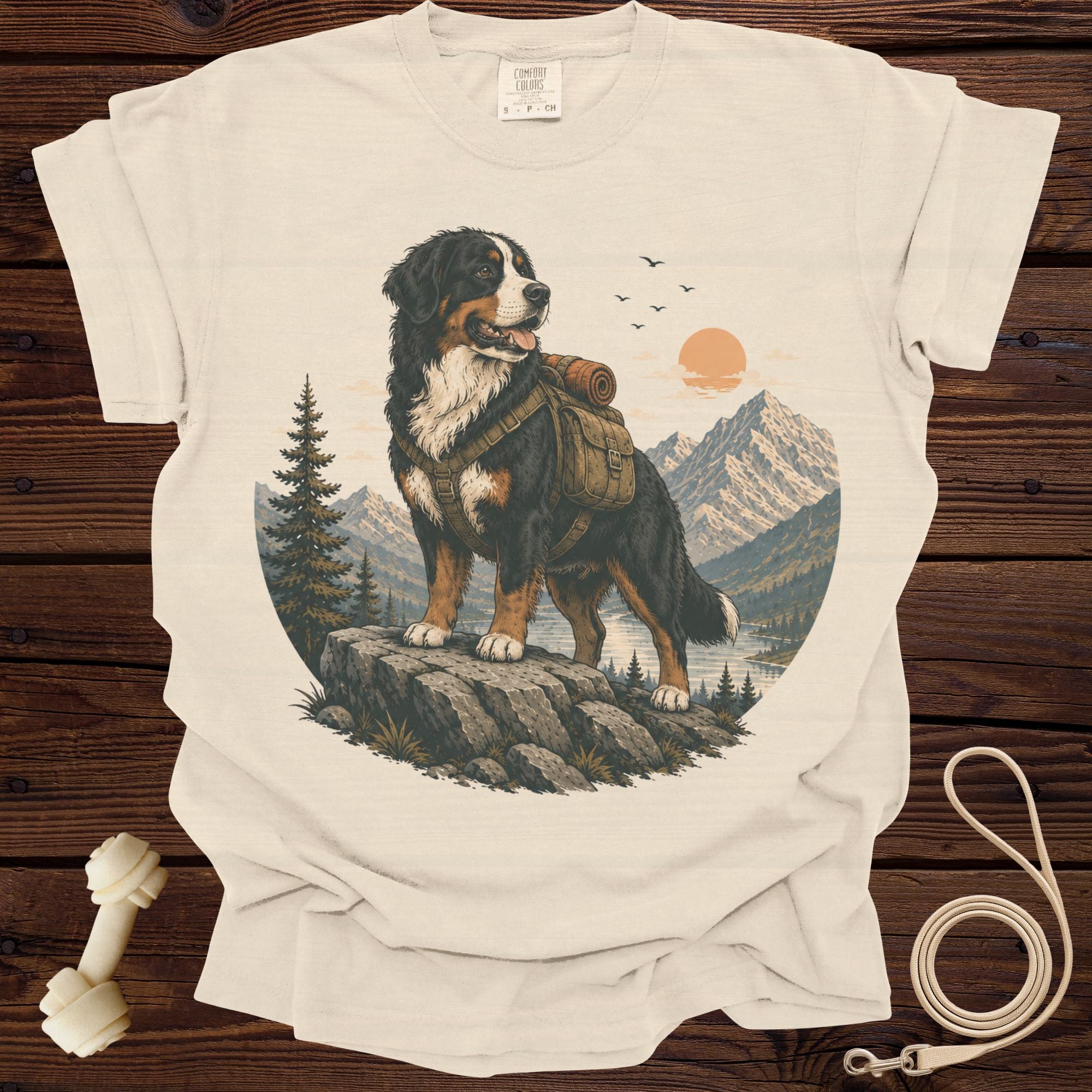 Bernese Mountain Dog wearing a backpack in a mountain landscape on a cream t-shirt.