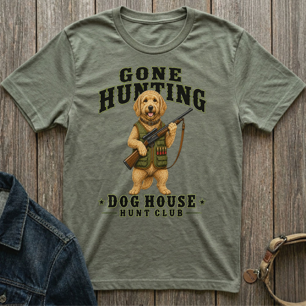 Green t-shirt with a doodle dog holding a shotgun, text reads "Gone Hunting Dog House Hunt Club".