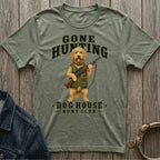 Green t-shirt with a doodle dog holding a shotgun, text reads "Gone Hunting Dog House Hunt Club".