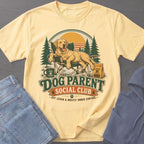 Yellow t-shirt with a labrador relaxing in a chair and "Dog Parent Social Club" text.