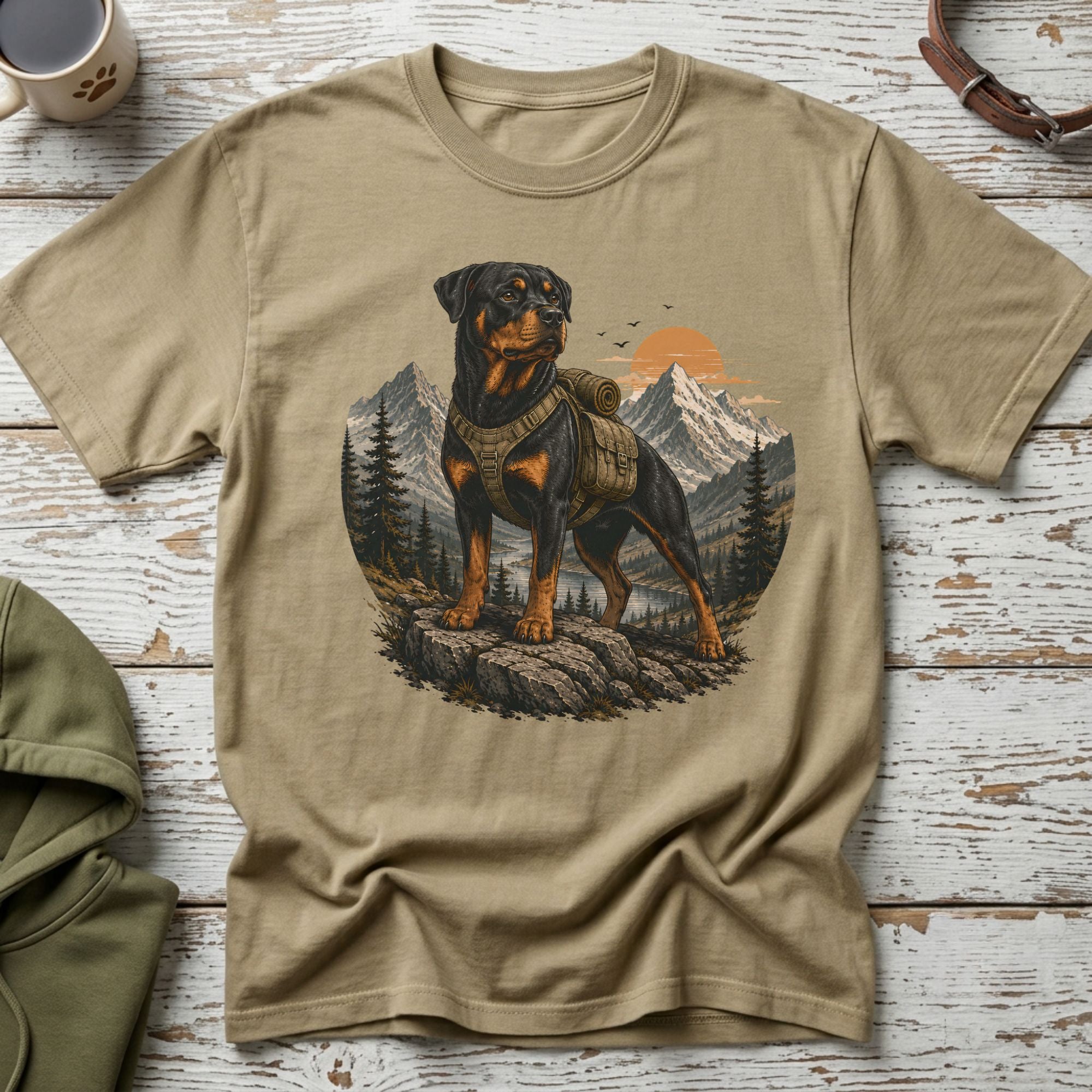 T-shirt with Rottweiler wearing a backpack in a mountain landscape graphic.