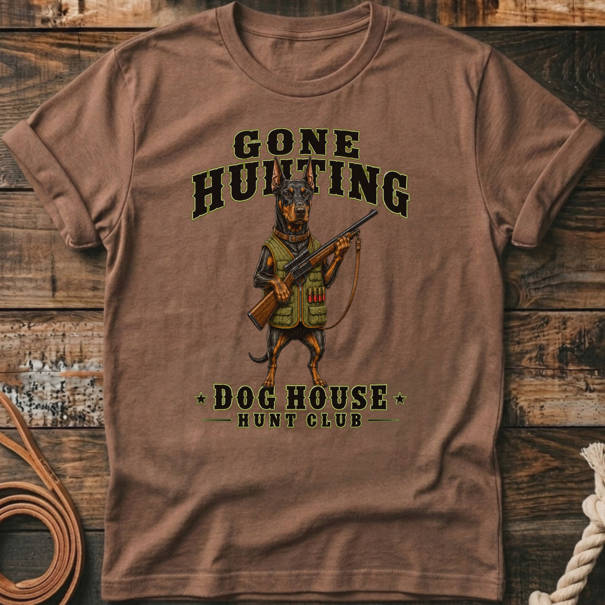 Brown t-shirt with Doberman dog holding a rifle and "Gone Hunting Dog House Hunt Club" text.