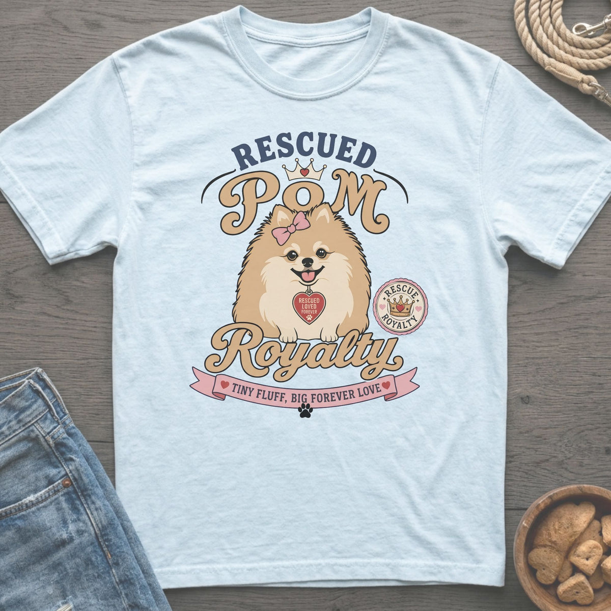 Light blue t-shirt graphic with "Rescued Pom Royalty" and a Pomeranian.
