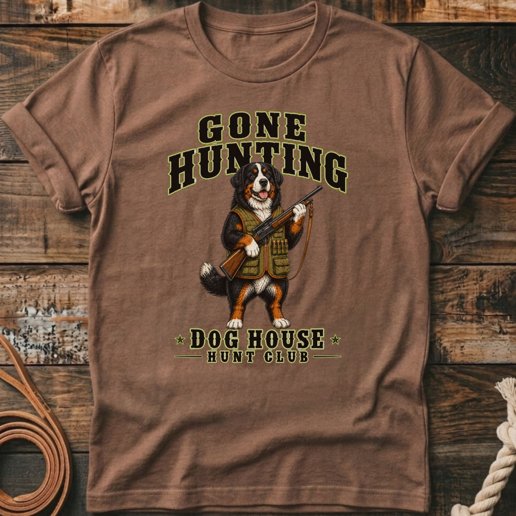 Bernese mountain dog wearing hunting vest holding rifle, text reads "Gone Hunting Dog House Hunt Club".