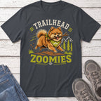 Pomeranian dog with stick runs through forest with text "TRAILHEAD ZOOMIES".