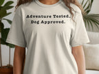 Light beige t-shirt with "Adventure Tested. Dog Approved." in black text.