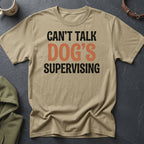Tan t-shirt with black and orange text reading "Can't talk Dog's Supervising".