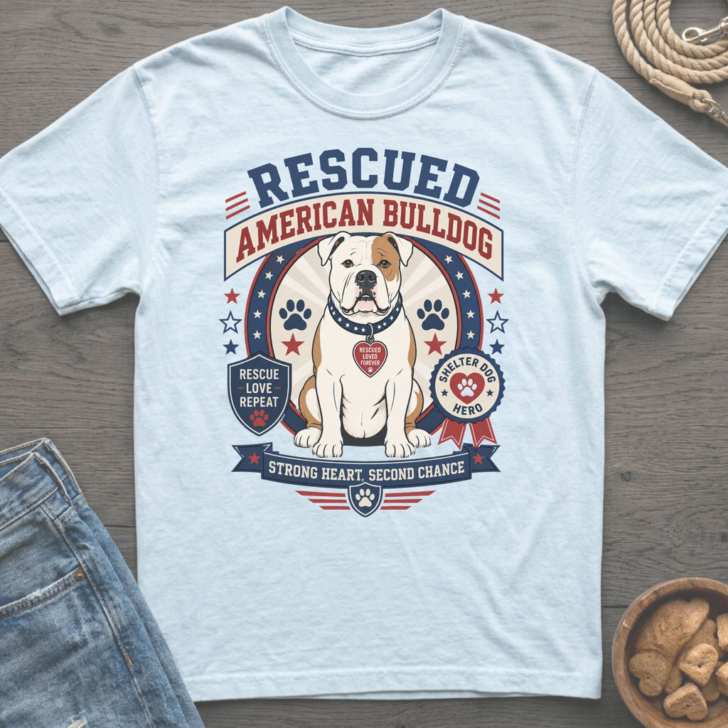 Light blue t-shirt featuring a graphic of a rescued American Bulldog with patriotic stars and stripes.