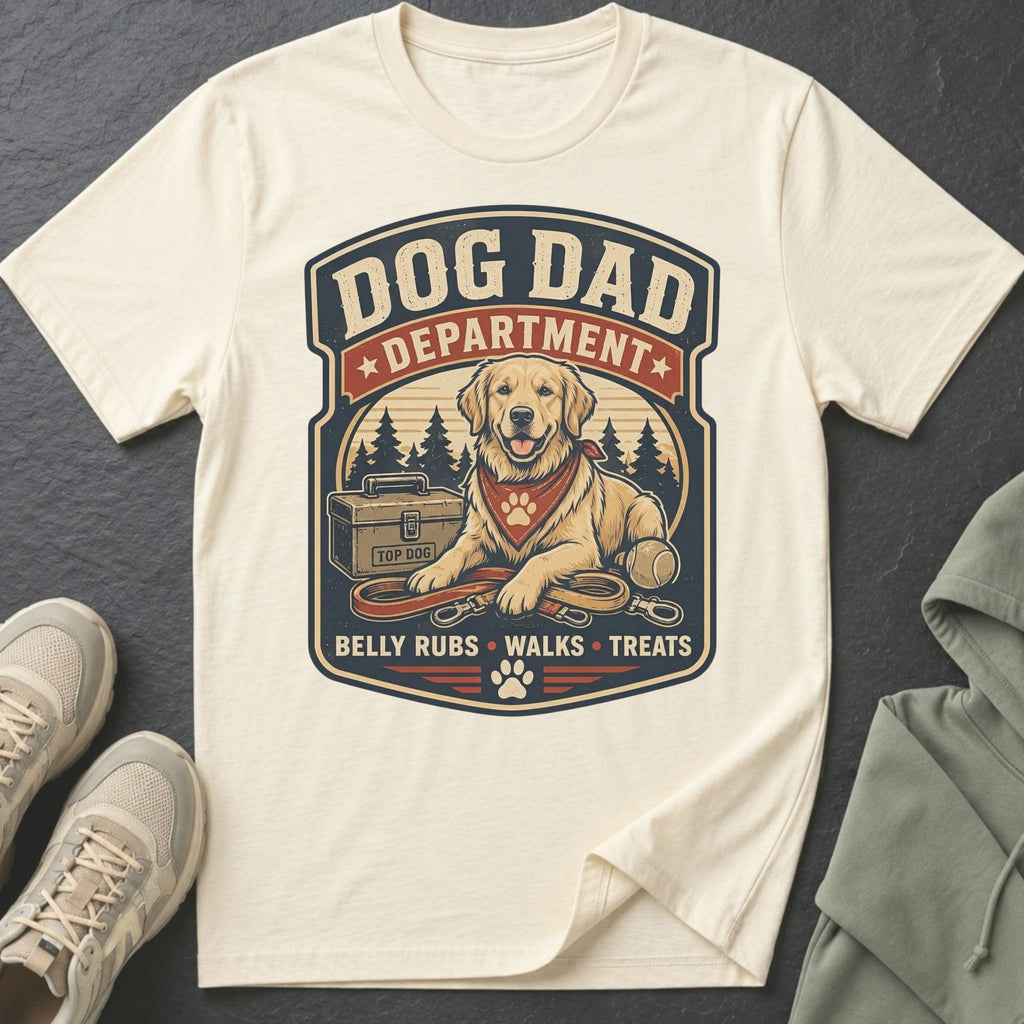 Cream t-shirt with "Dog Dad Department" graphic featuring a golden retriever, leash, and tennis ball.