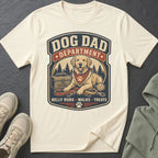 Cream t-shirt with "Dog Dad Department" graphic featuring a golden retriever, leash, and tennis ball.
