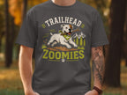 White dog with bandana runs with stick, text "TRAILHEAD ZOOMIES".