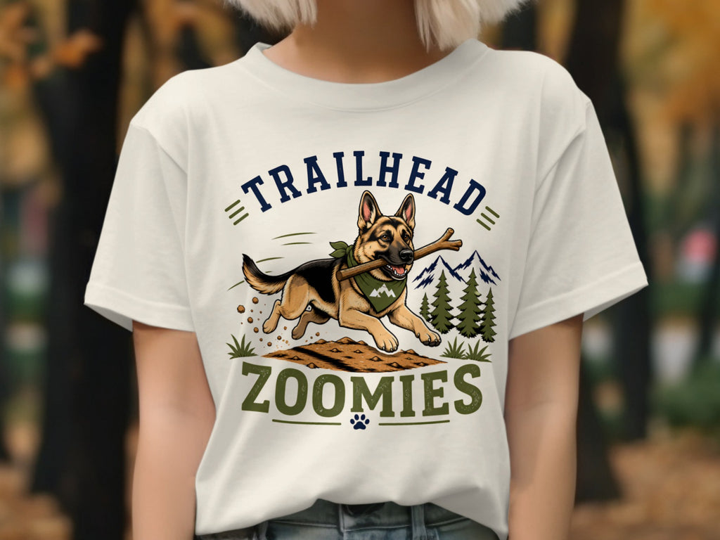 German Shepherd running with stick, text "TRAILHEAD ZOOMIES", mountains and trees.