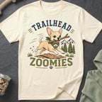 Chihuahua with stick runs through dirt with text "TRAILHEAD ZOOMIES"