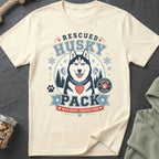 Cream t-shirt with a graphic of a rescued husky, snowflakes, and text "Rescued Husky Pack".