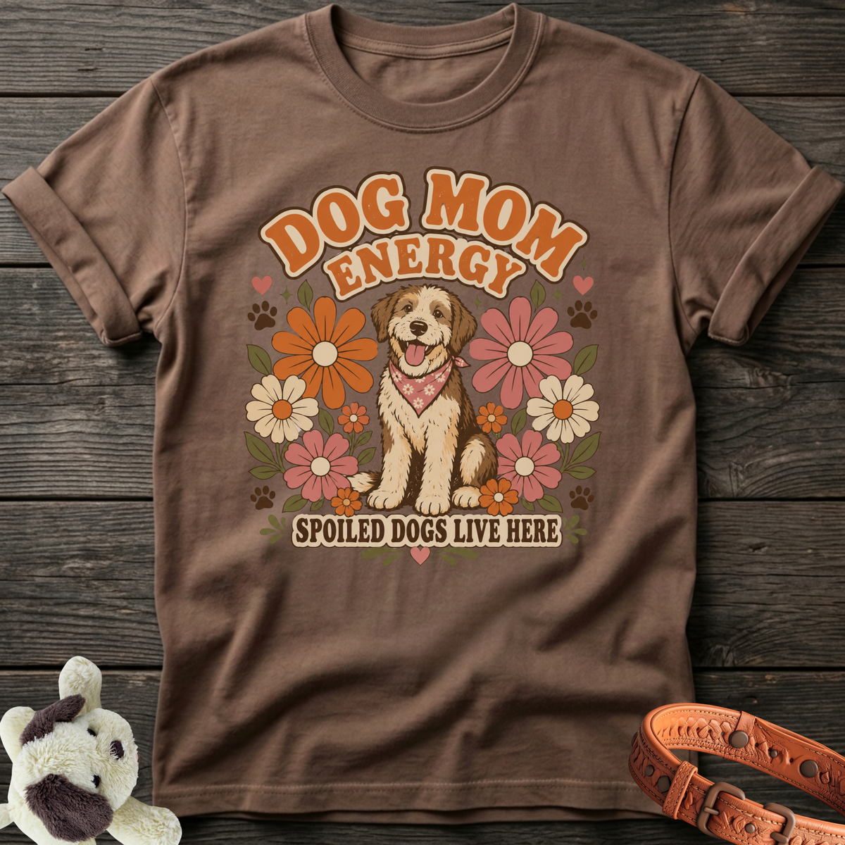 Brown t-shirt with "Dog Mom Energy Spoiled Dogs Live Here" and a happy dog surrounded by flowers.
