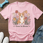 Pink t-shirt with cartoon corgi sitting among tulips and text "Paws in Bloom".