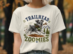 T-shirt graphic with running schnauzer, stick, and text "TRAILHEAD ZOOMIES"