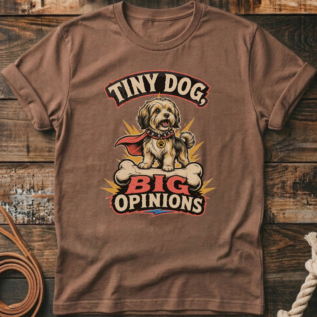 Brown t-shirt with a small dog wearing a cape and sitting on a bone with text.