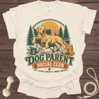 Cream t-shirt with "Dog Parent Social Club" graphic featuring a happy dog in a chair.