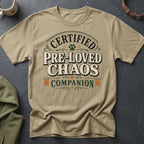 Tan t-shirt with text "Certified Pre-Loved Chaos Companion" and dog paw graphic.