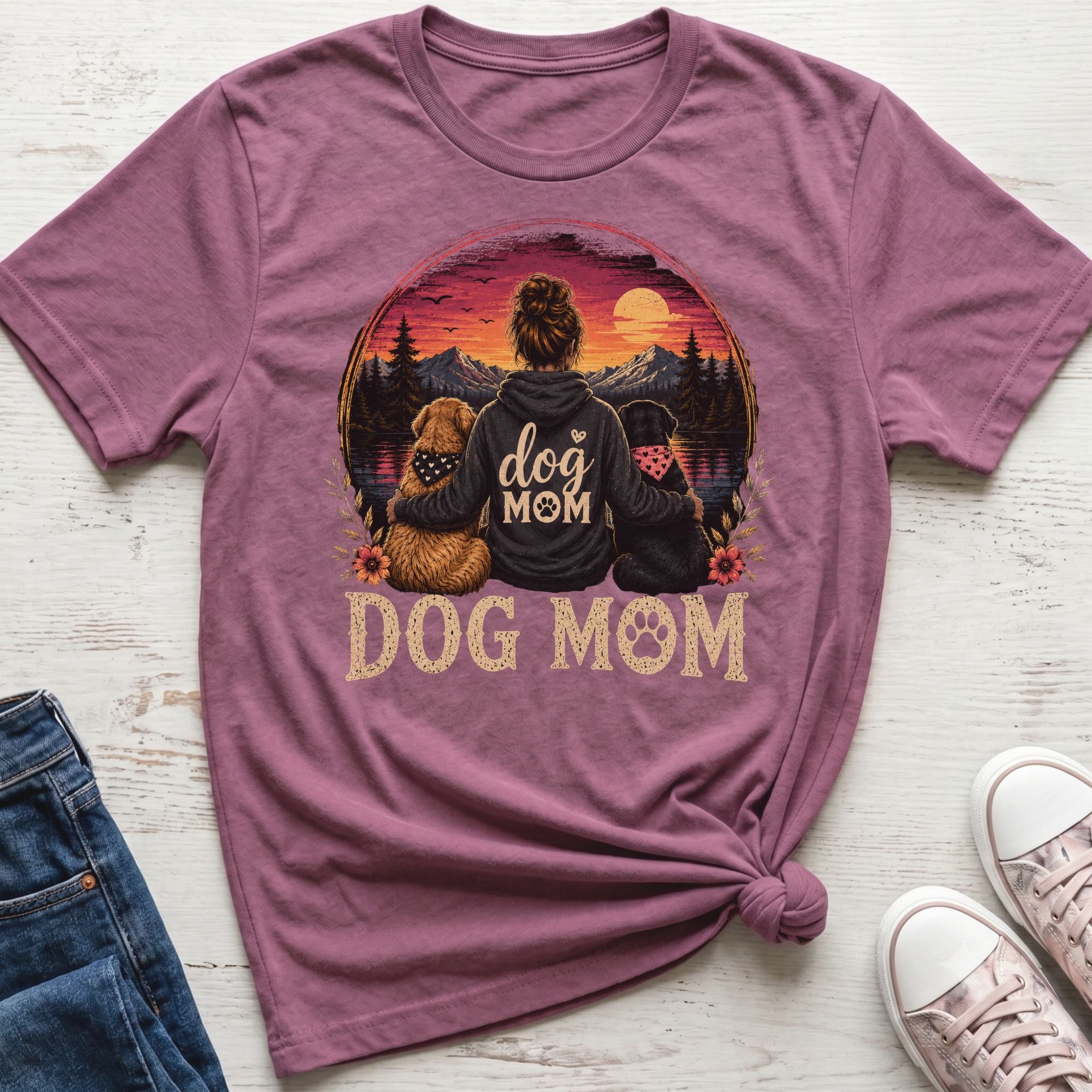 Woman with two dogs in front of sunset landscape with "Dog Mom" text.