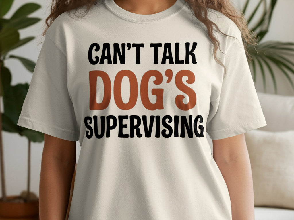 Cream t-shirt with "CAN'T TALK DOG'S SUPERVISING" text.