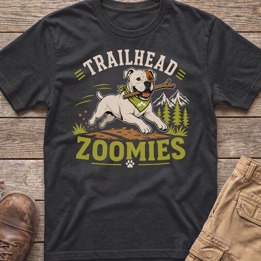 White dog with bandana runs with stick, "Trailhead Zoomies" text, mountains.
