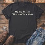 Dark t-shirt with white text "My Dog Thinks 'Shortcut' Is a Myth".