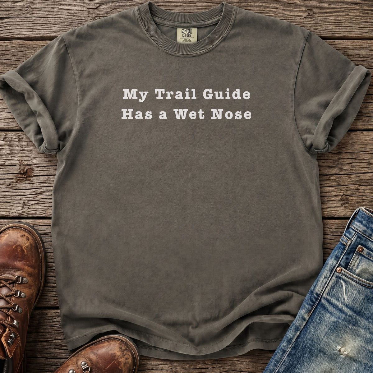 T-shirt with "My Trail Guide Has a Wet Nose" text, boots, and jeans.