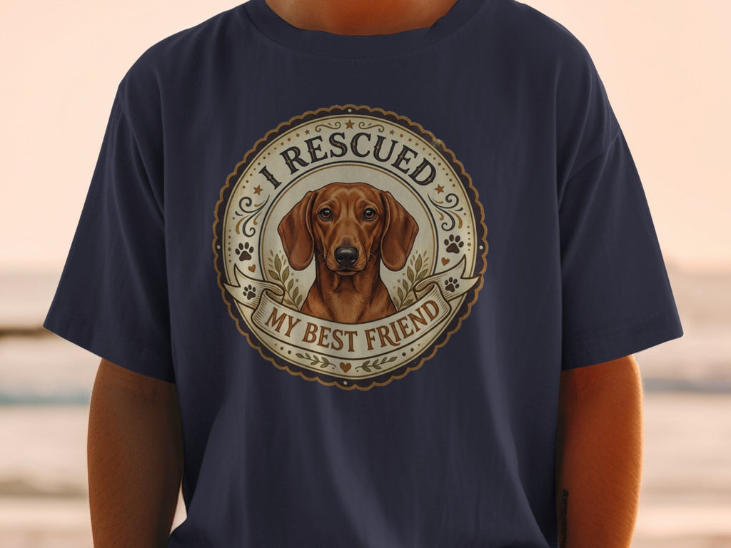 Dachshund graphic with text "I RESCUED MY BEST FRIEND" on navy shirt.