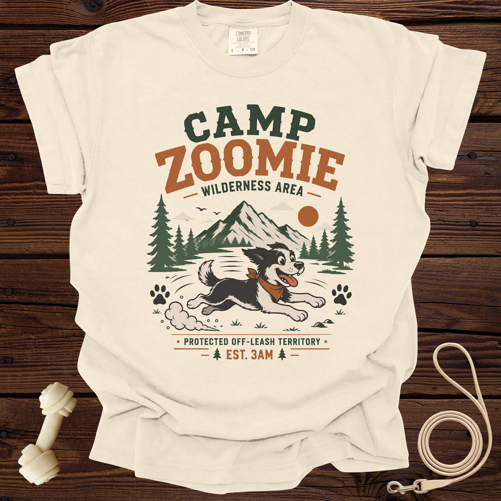 Cream t-shirt with "CAMP ZOOMIE WILDERNESS AREA" graphic and running dog.