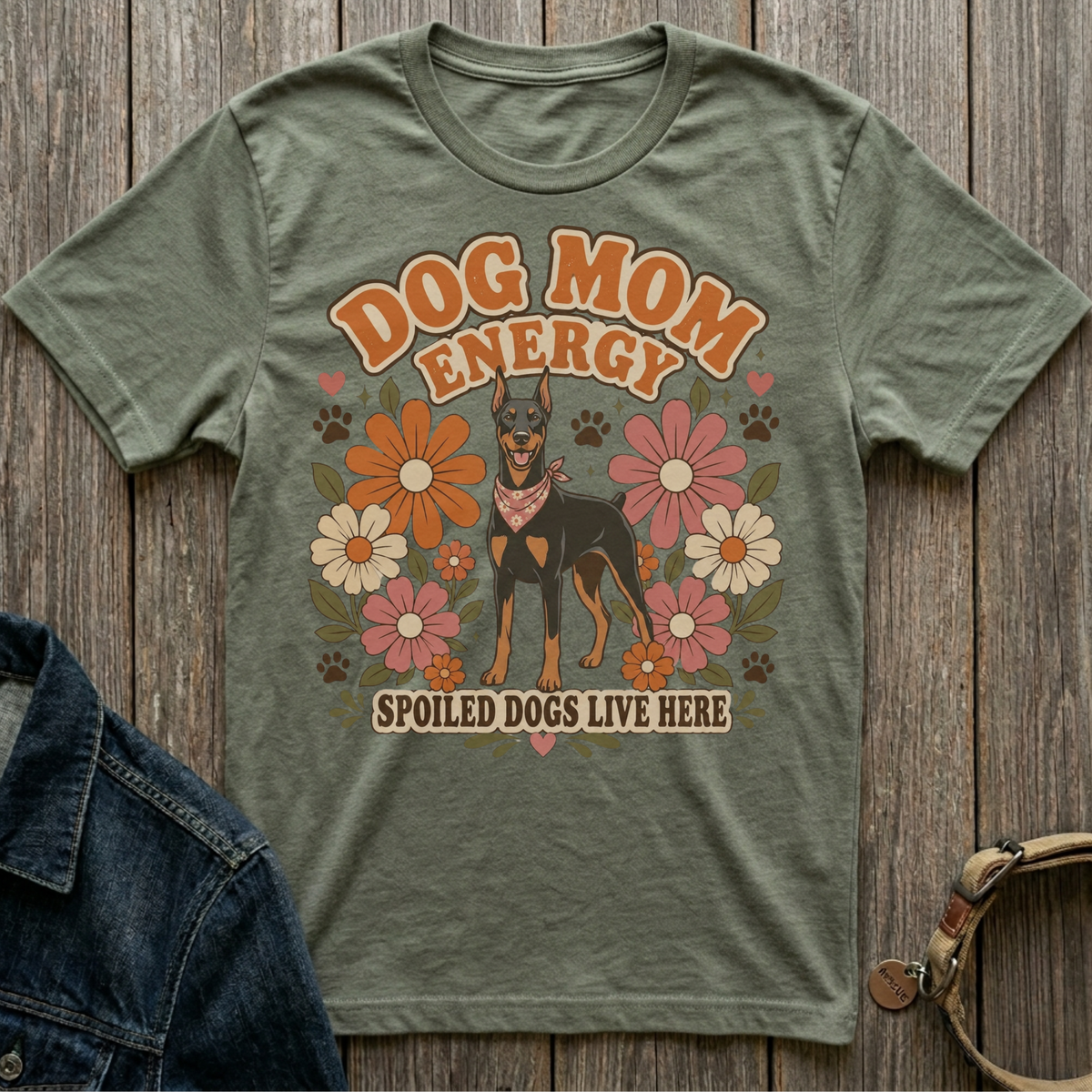 Green t-shirt with a Doberman, flowers, and text "DOG MOM ENERGY SPOILED DOGS LIVE HERE".
