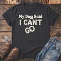 Black t-shirt with "My Dog Said I CAN'T GO" text, jeans, and boots.