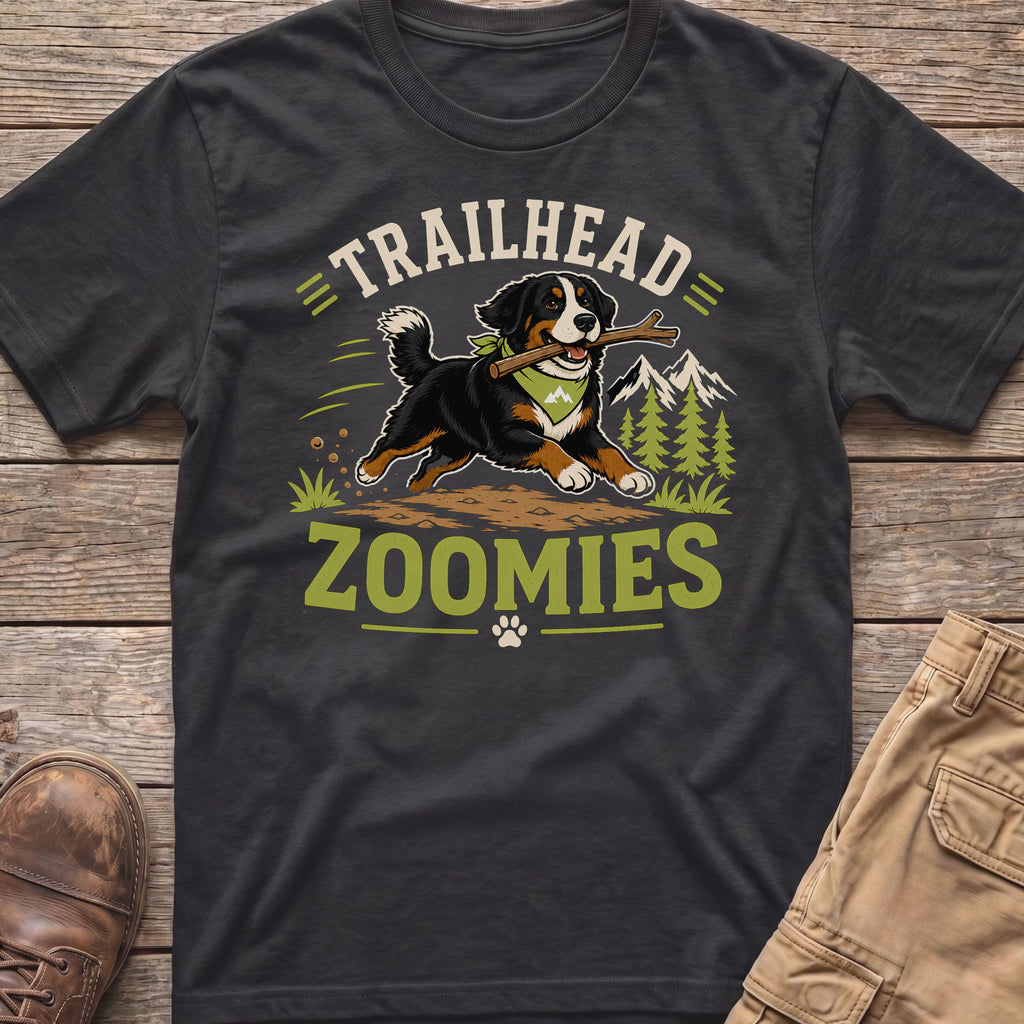 Bernese Mountain Dog with stick, "TRAILHEAD ZOOMIES" text, mountains, and trees graphic on t-shirt.