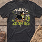 Bernese Mountain Dog with stick, "TRAILHEAD ZOOMIES" text, mountains, and trees graphic on t-shirt.