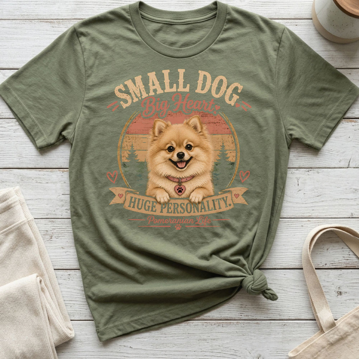 Green t-shirt with Pomeranian dog art and "Small Dog Big Heart" text.