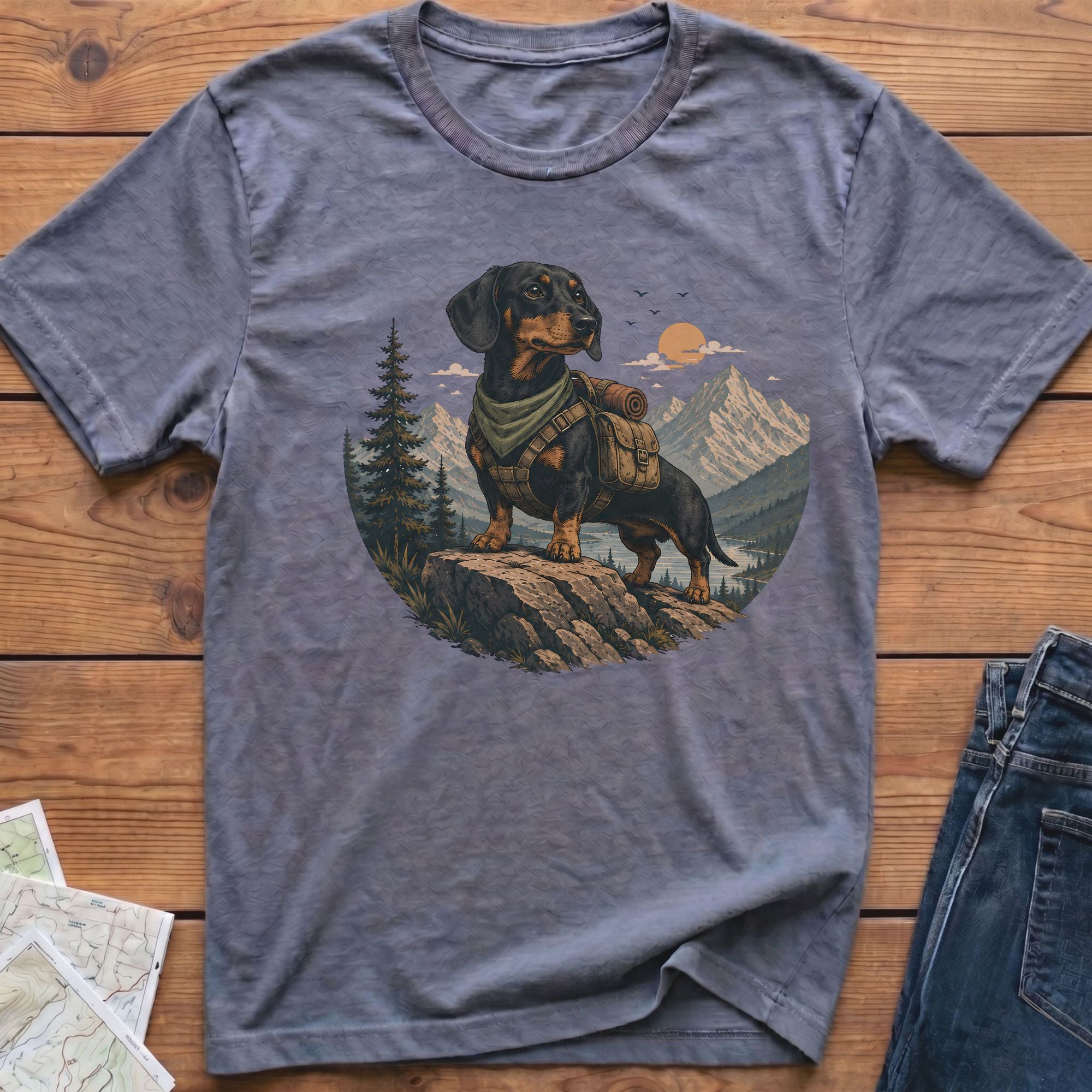 Dachshund wearing a backpack and bandana on a rock with mountains.