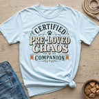Light blue t-shirt with "Certified Pre-Loved Chaos Companion" text and paw print.