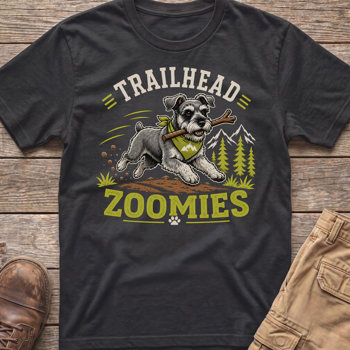 Miniature Schnauzer with stick on a dirt path, with "TRAILHEAD ZOOMIES" text.