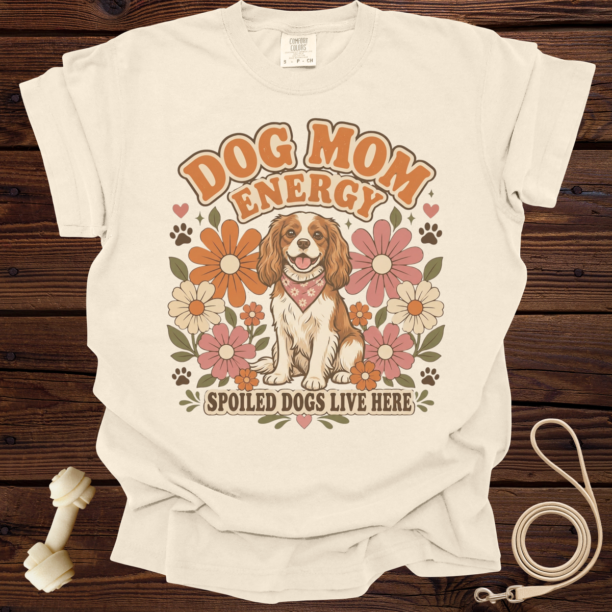 Cream t-shirt with "DOG MOM ENERGY" and a dog surrounded by retro flowers.