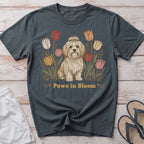 T-shirt with a cute fluffy dog surrounded by colorful tulips and the text "Paws in Bloom".